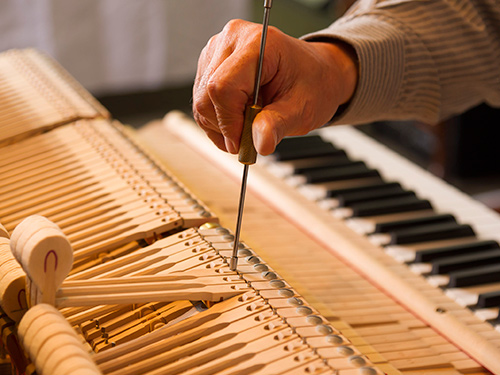 Persona reparando piano