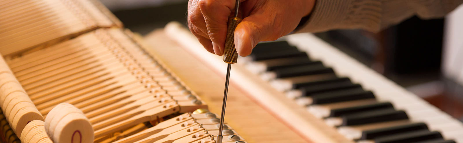 Hombre realizando reparación a un piano